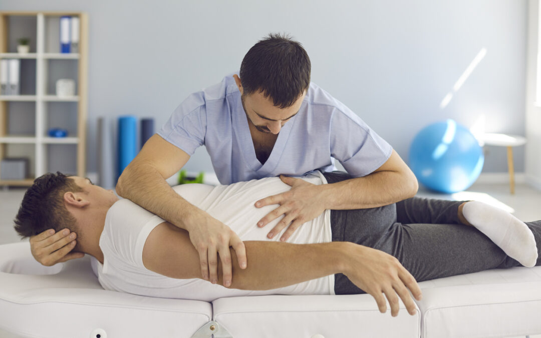Chiropractor, osteopath, physiotherapist or manual therapist working with male patient