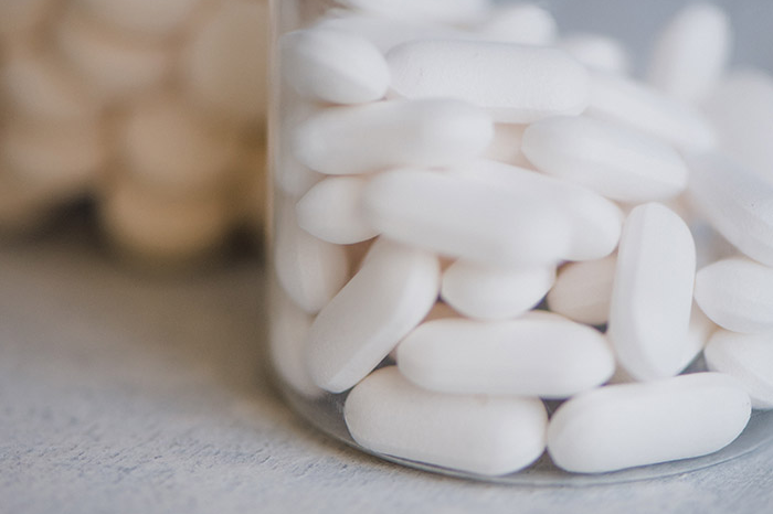 A cropped closeup of a bottle of pills.